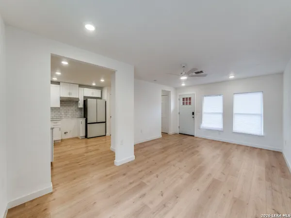 a view of an empty room with wooden floor