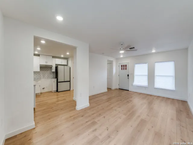 a view of an empty room with wooden floor