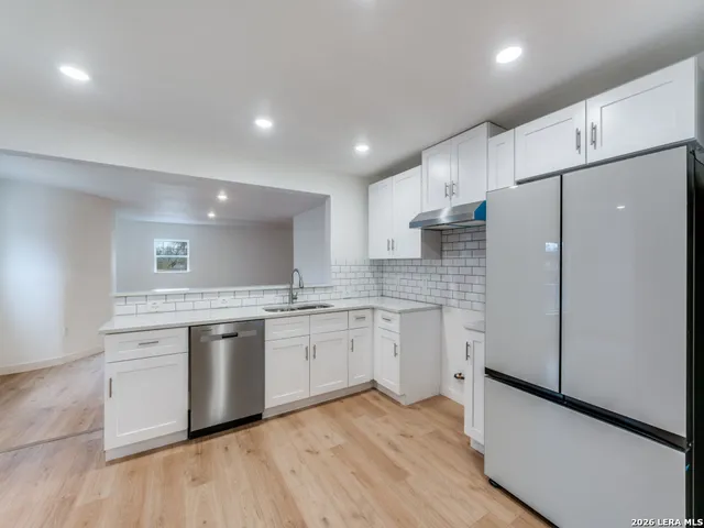 a kitchen with granite countertop white cabinets and white appliances