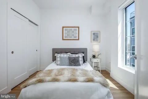 a large bed sitting in a bedroom next to a window