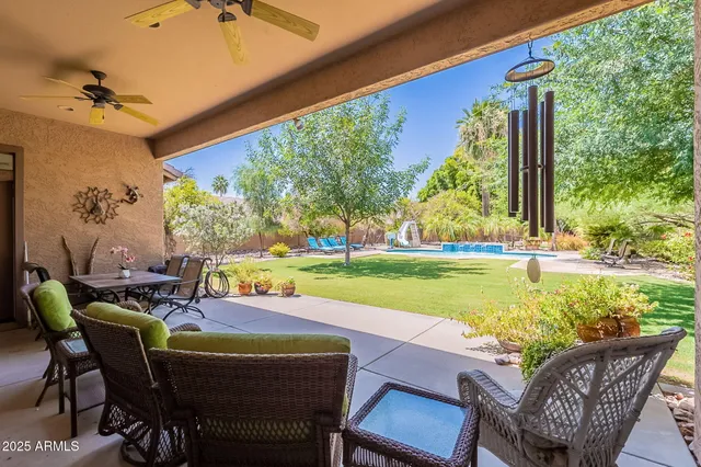 a view of a patio with a table chairs and a swimming pool