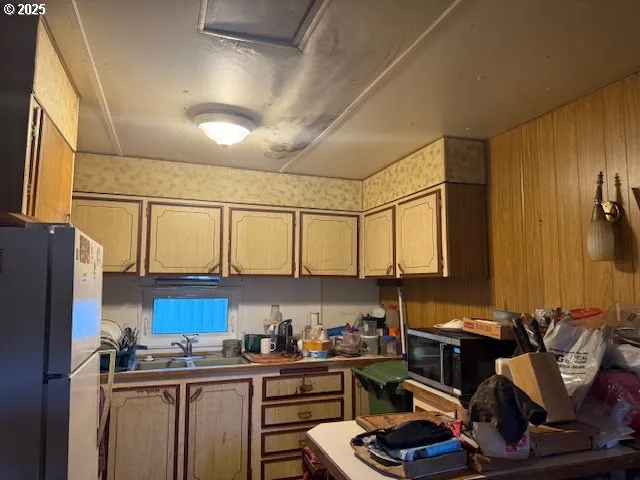 a kitchen with stainless steel appliances a sink cabinets and wooden floor