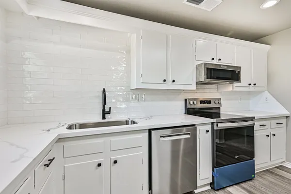 a kitchen with white cabinets and white appliances