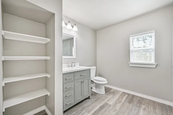a bathroom with a toilet sink a mirror and vanity