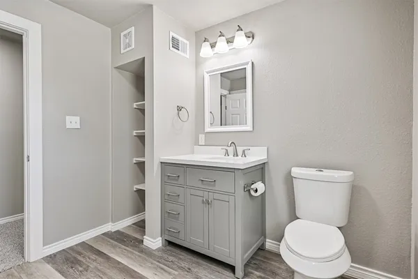 a bathroom with a toilet a sink a mirror and a shower