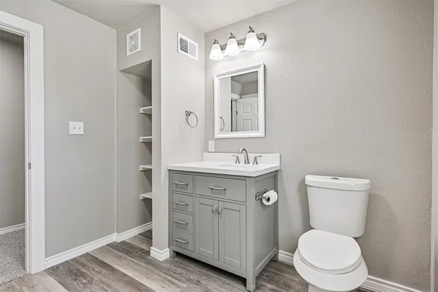 a bathroom with a toilet a sink a mirror and a shower