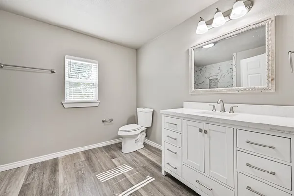 a spacious bathroom with a toilet sink and mirror