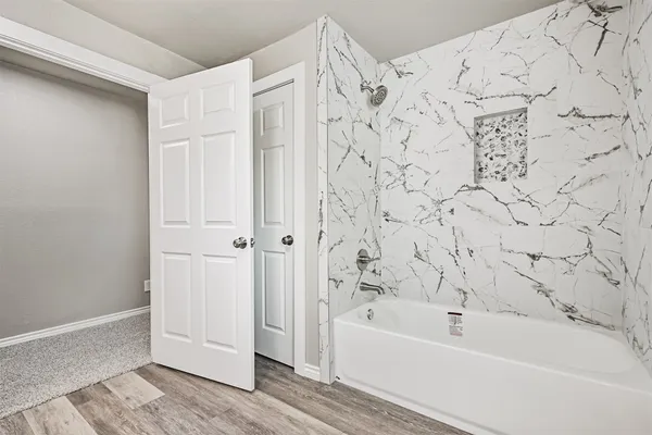 a bathroom with bathtub and shower