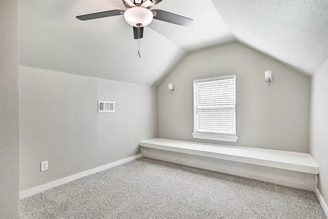 en empty room with ceiling fan and window
