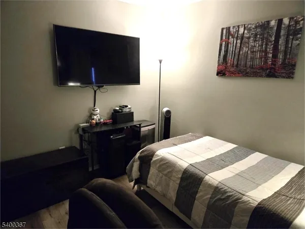 a bedroom with a bed tv and wall painting