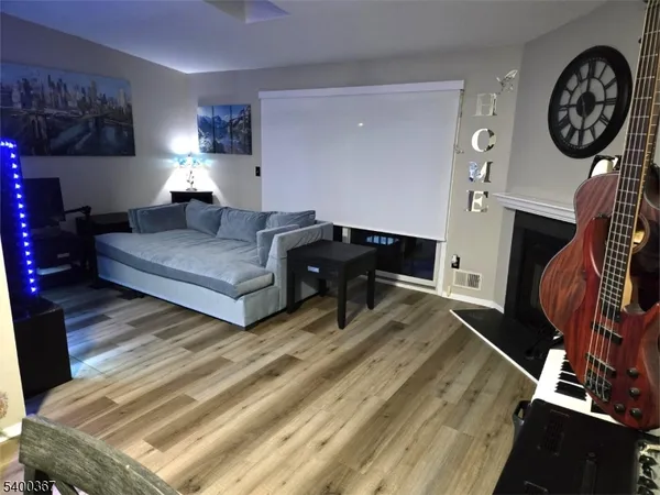 a living room with furniture a clock on wall and a lamp