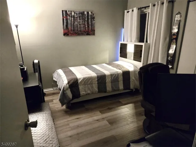 a bedroom with a bed and wooden floor