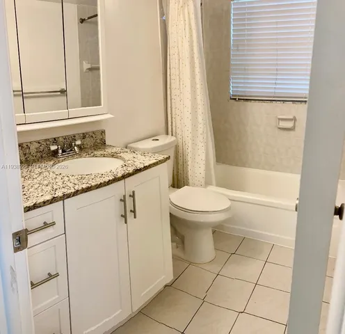 a bathroom with a granite countertop sink a toilet and a mirror