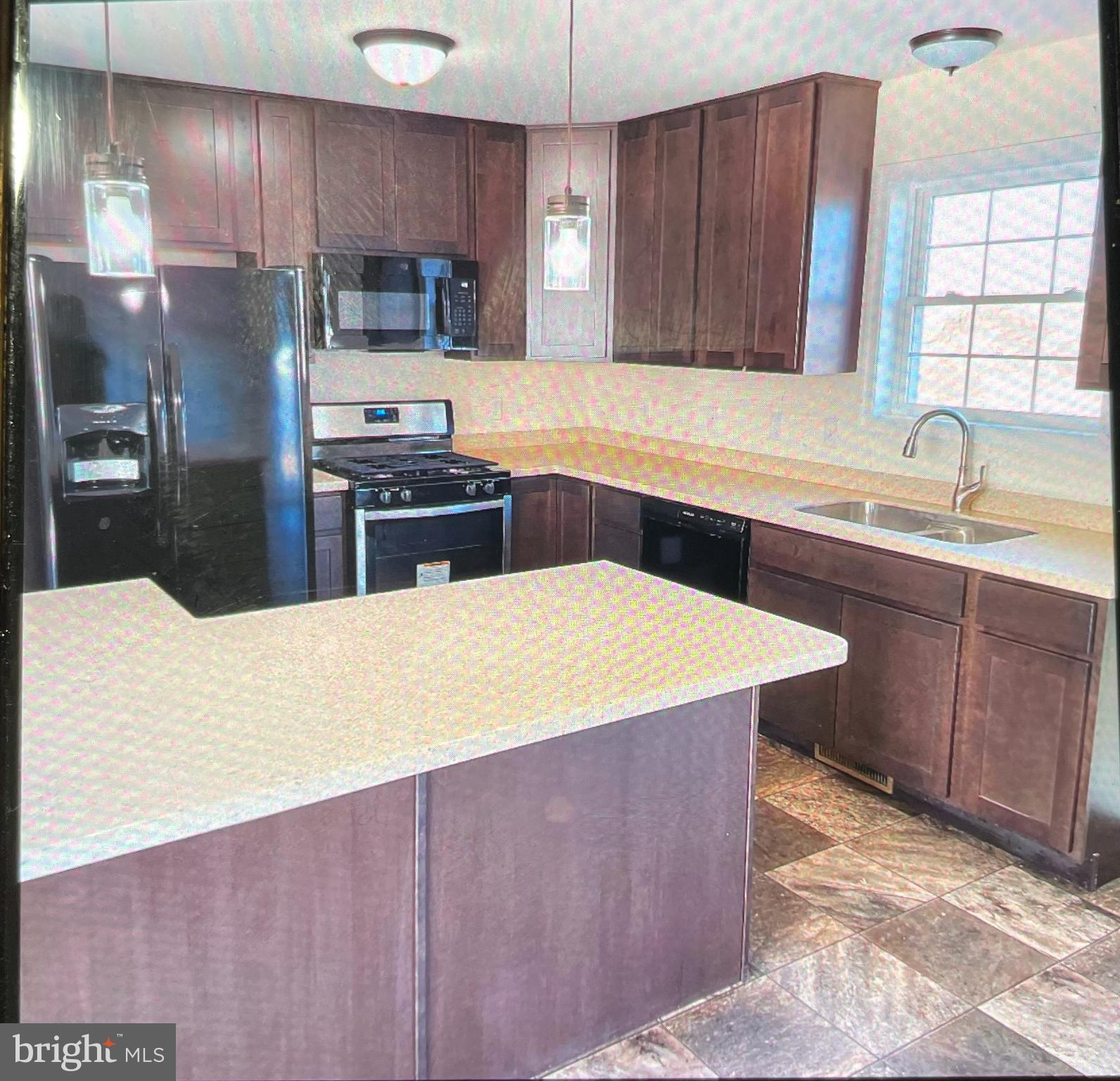 717 Bethayres Street Harrington, DE 19952 - Photo 3 of 7 a kitchen with stainless steel appliances a sink a stove a refrigerator cabinets and a counter top space