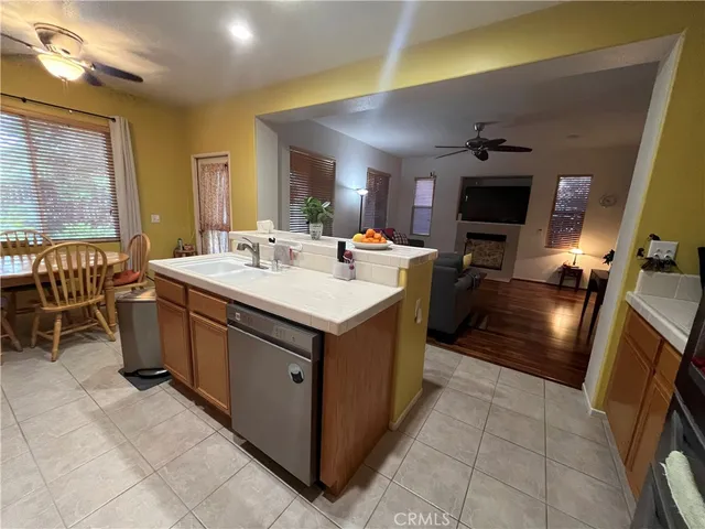 a kitchen with a sink stainless steel appliances a refrigerator and a counter top space