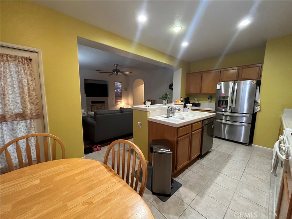 1483 Albillo Loop Perris, CA 92571 - Photo 14 of 46 a kitchen with a sink stainless steel appliances a refrigerator and a counter top space