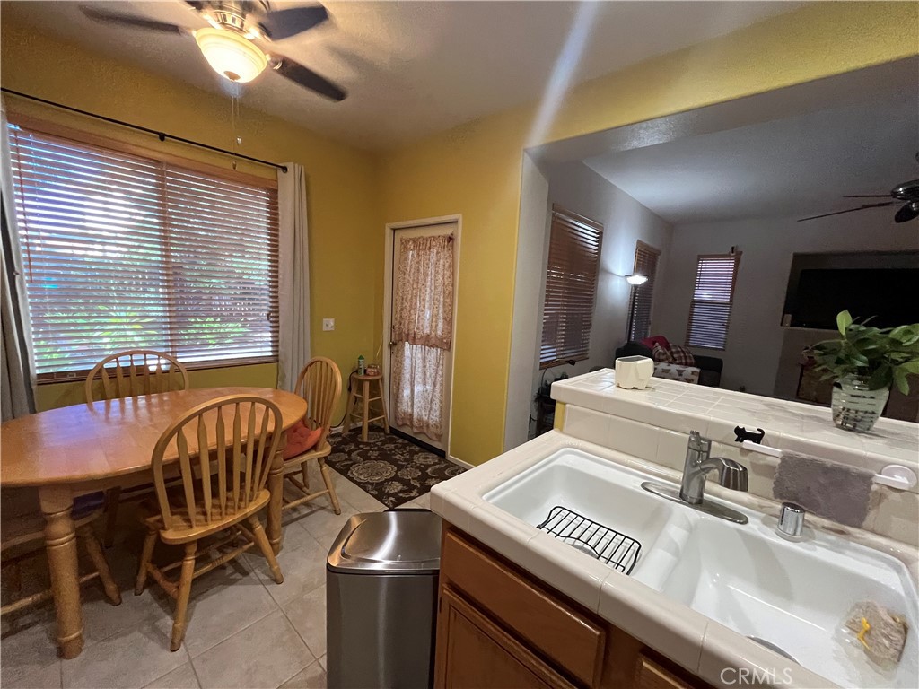 1483 Albillo Loop Perris, CA 92571 - Photo 16 of 46 a kitchen with a table chairs stove and cabinets