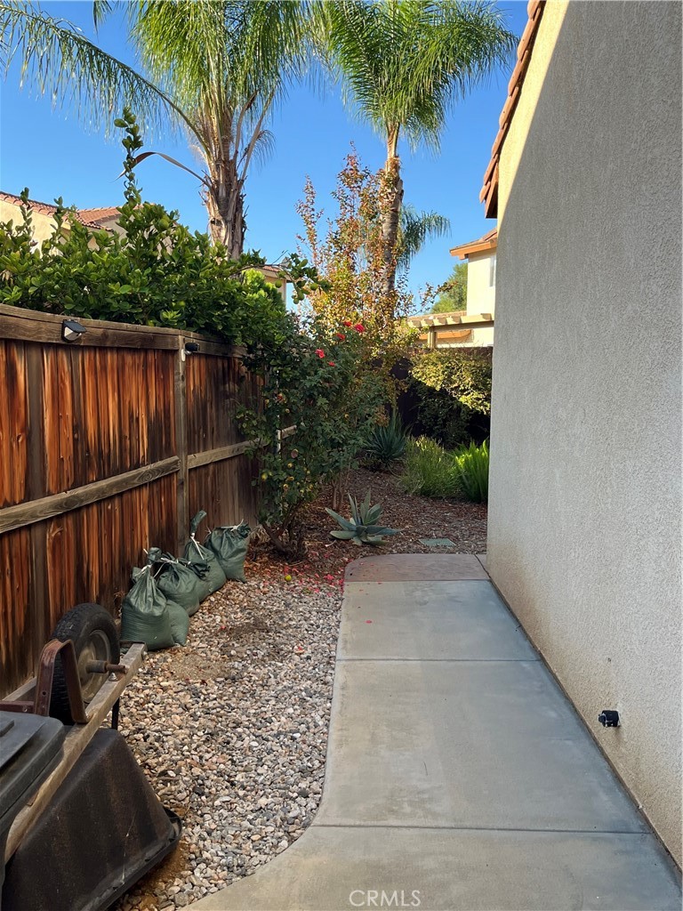 1483 Albillo Loop Perris, CA 92571 - Photo 31 of 46 a view of a backyard with plants and a lawn chairs