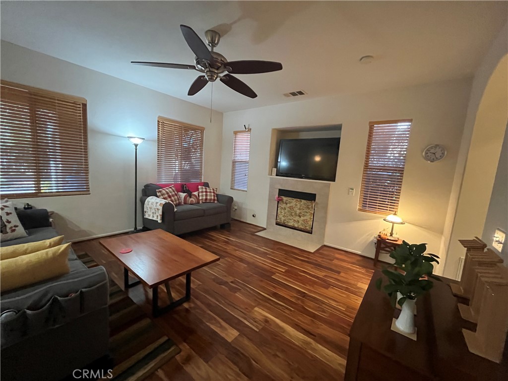 1483 Albillo Loop Perris, CA 92571 - Photo 7 of 46 a living room with furniture a flat screen tv and a fireplace