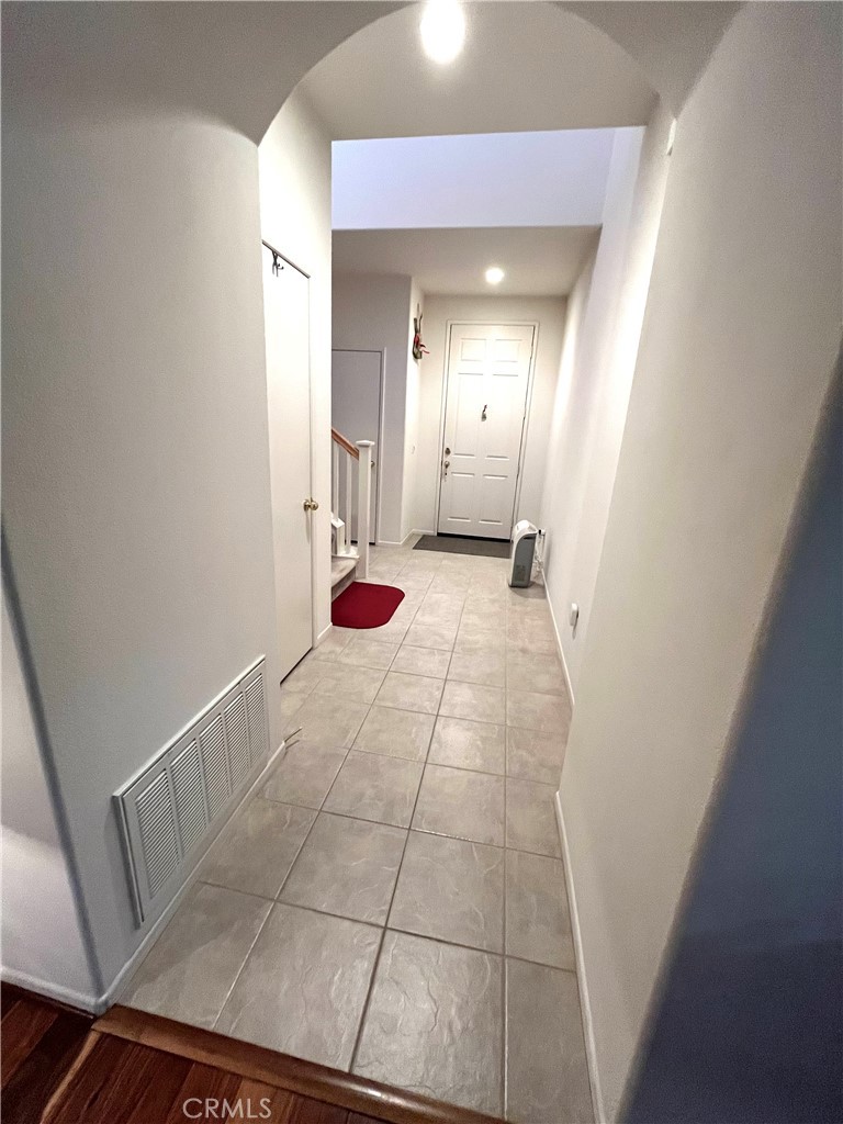 1483 Albillo Loop Perris, CA 92571 - Photo 9 of 46 a view of a hallway with wooden floor and staircase