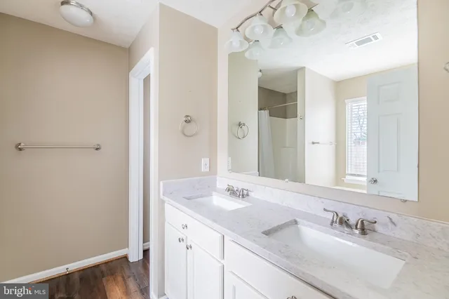 a bathroom with a sink vanity granite shower and a mirror