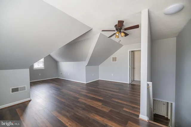 a view of a livingroom with wooden floor and a ceiling fan