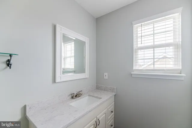 a bathroom with a sink vanity and a mirror