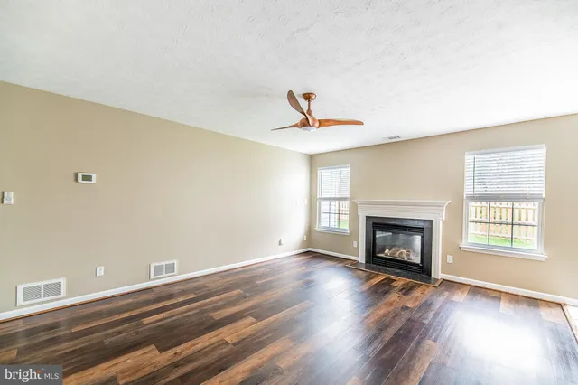 a living room with wooden floor and a fireplace