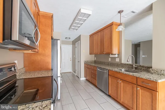 a bathroom with a granite countertop sink a mirror and a shower