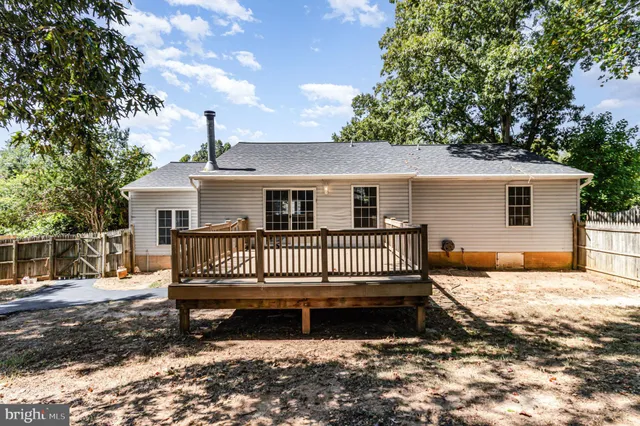 a view of a house with a wooden deck and a yard