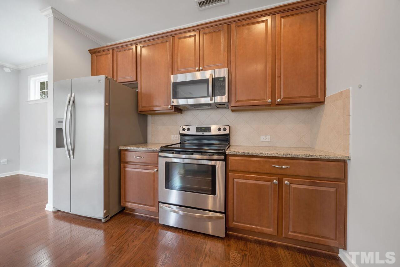1026 Ileagnes Road Raleigh, NC 27603 - Photo 12 of 29 a kitchen with stainless steel appliances granite countertop a refrigerator stove and microwave