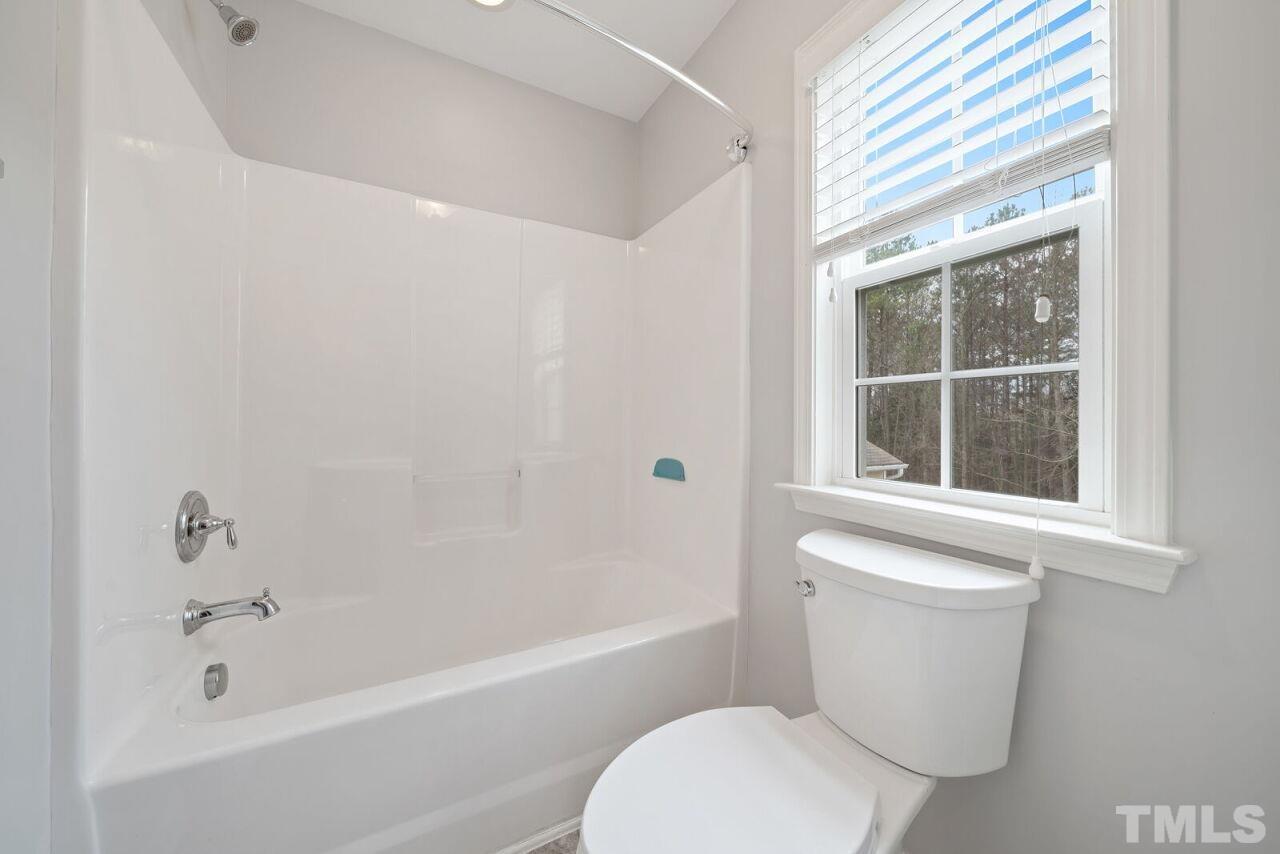 1026 Ileagnes Road Raleigh, NC 27603 - Photo 17 of 29 a white toilet sitting next to a bath tub