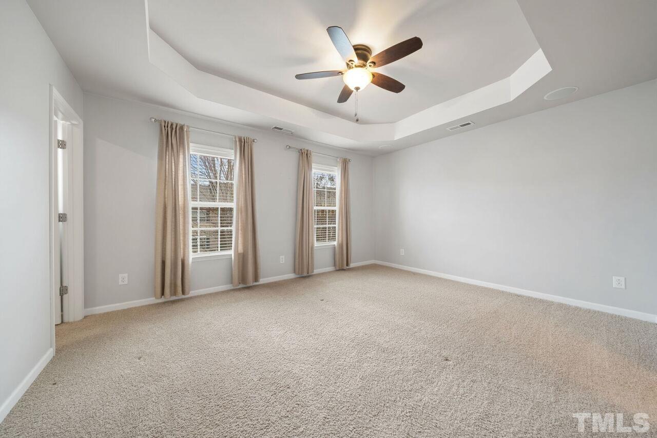 1026 Ileagnes Road Raleigh, NC 27603 - Photo 20 of 29 an empty room with windows and ceiling fan