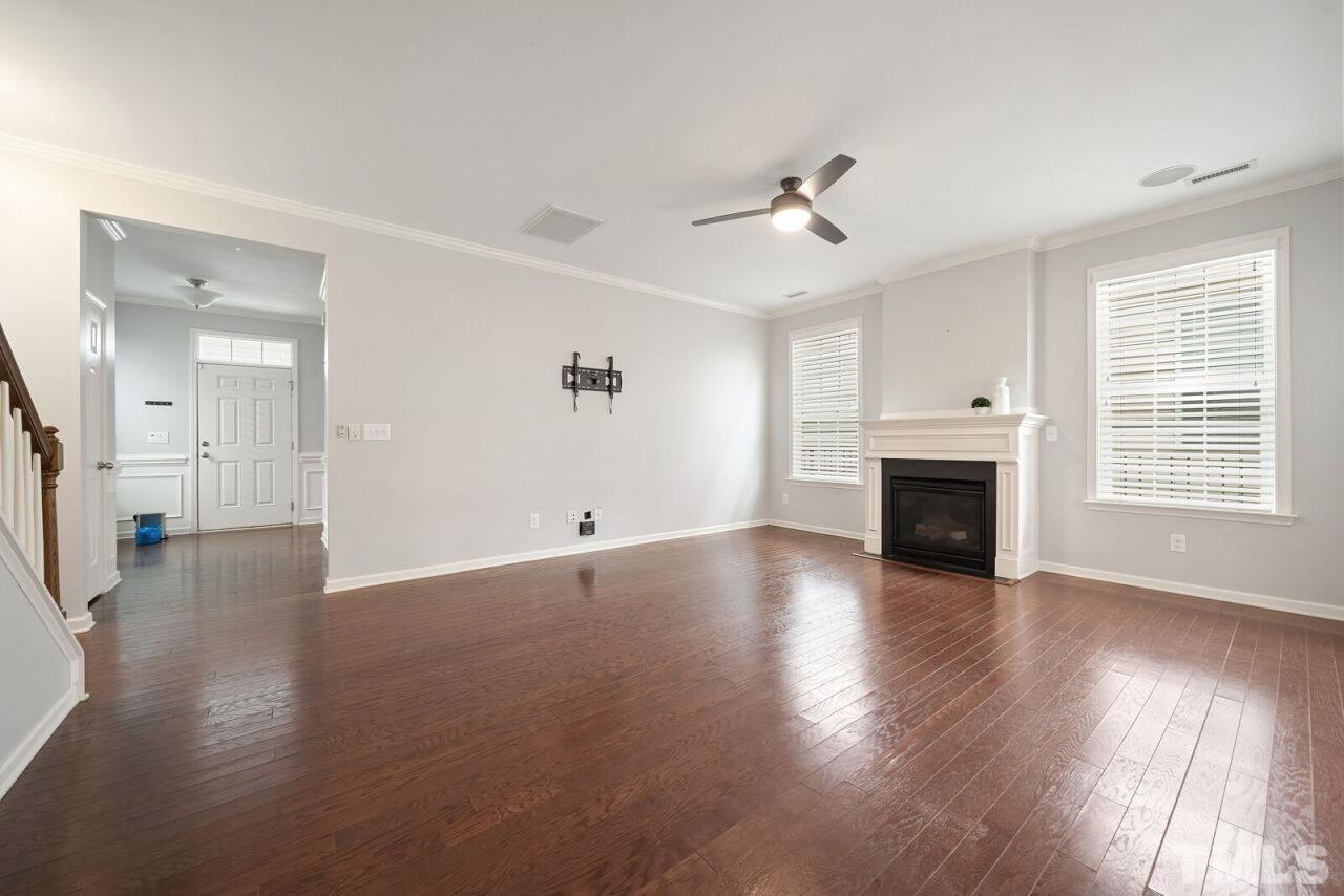 1026 Ileagnes Road Raleigh, NC 27603 - Photo 9 of 29 an empty room with wooden floor fireplace and windows