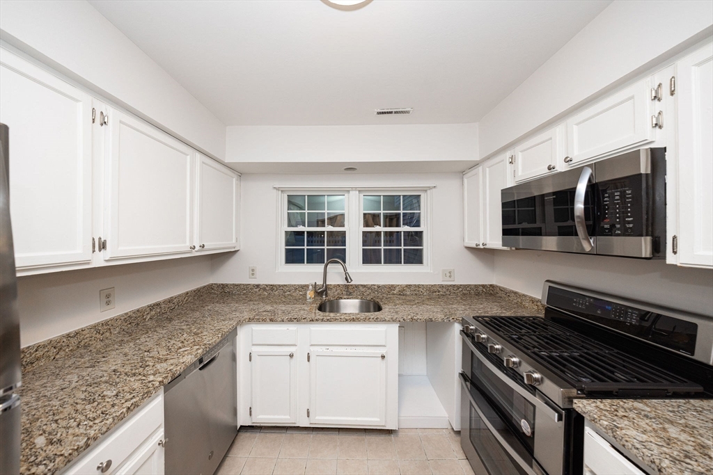 618 Edgebrook Drive, Unit 618 Boylston, MA 01505 - Photo 7 of 37 a kitchen with granite countertop a sink and a stove top oven