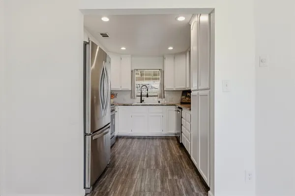 a kitchen with a refrigerator sink and cabinets