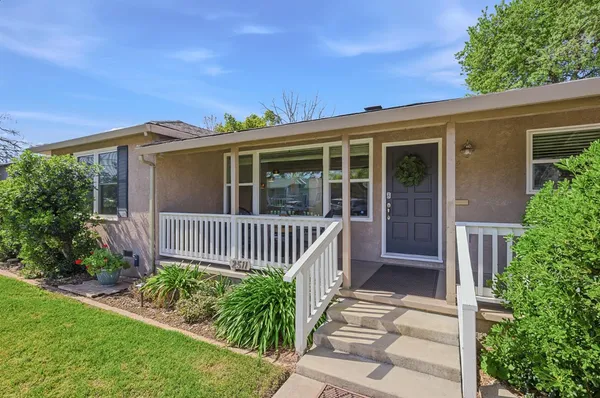a view of a house with a small yard and wooden floor and fence