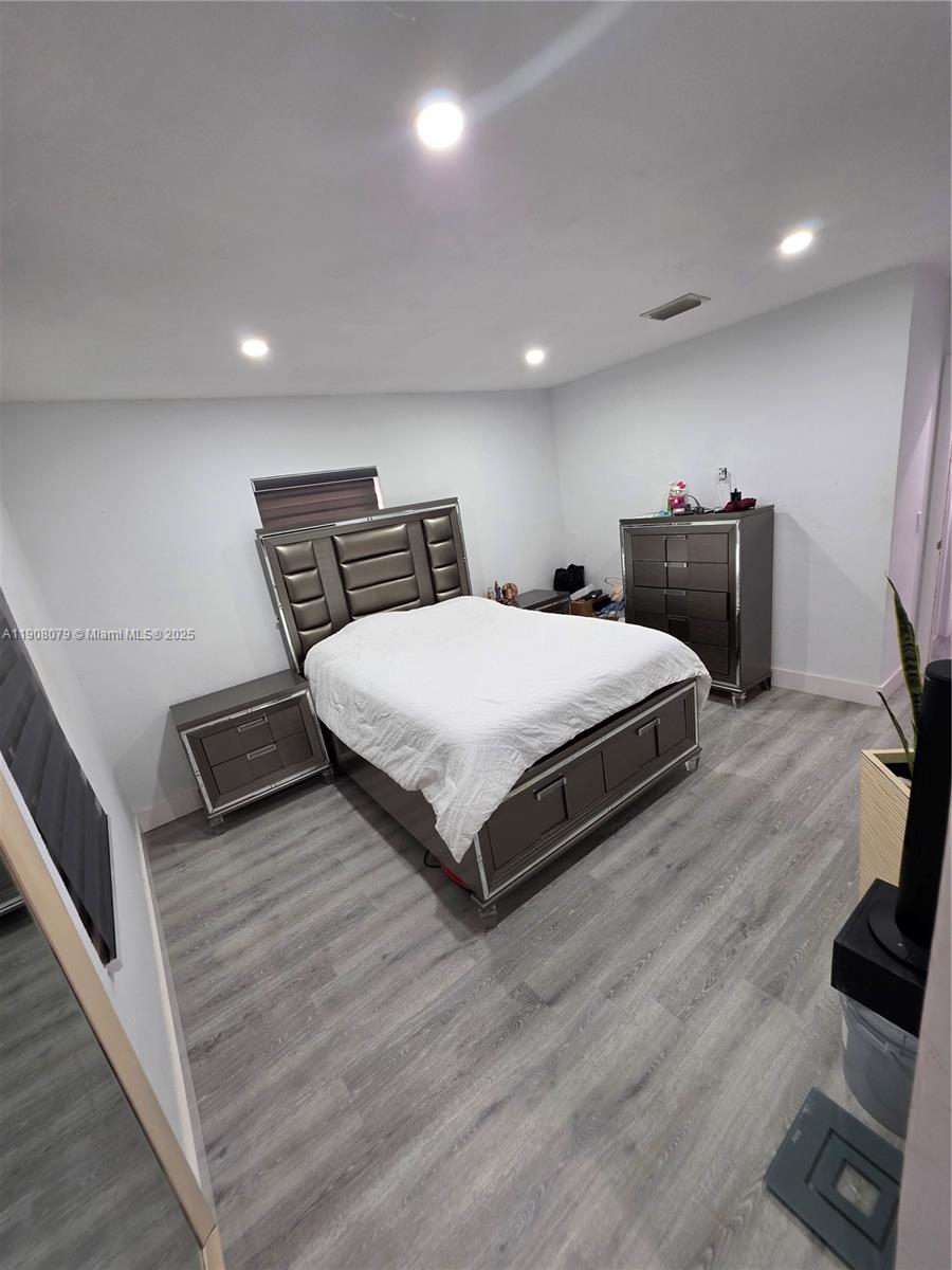 18200 Southwest 262nd Street Homestead, FL 33031 - Photo 19 of 30 a bedroom with a bed and wooden floor