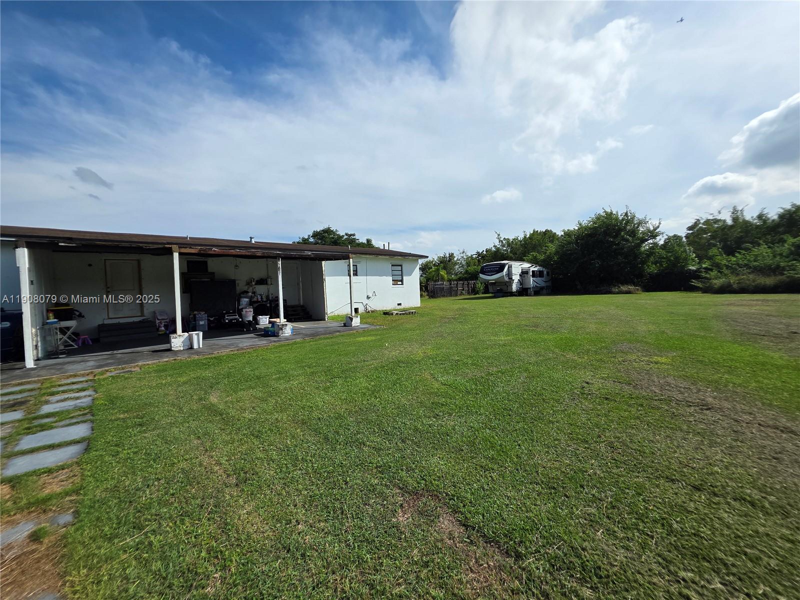 18200 Southwest 262nd Street Homestead, FL 33031 - Photo 26 of 30 a front view of a house with a garden and porch