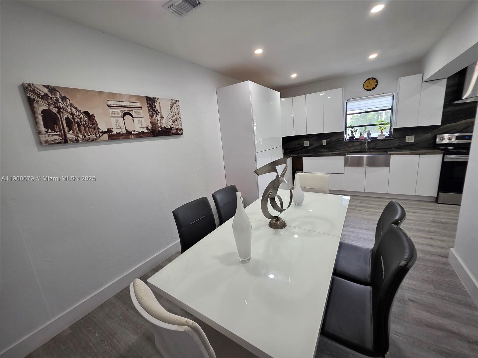 18200 Southwest 262nd Street Homestead, FL 33031 - Photo 9 of 30 a kitchen with stainless steel appliances granite countertop a sink a microwave a refrigerator a stove with white cabinets and wooden floor