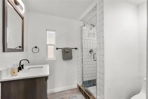 a bathroom with a shower sink and mirror