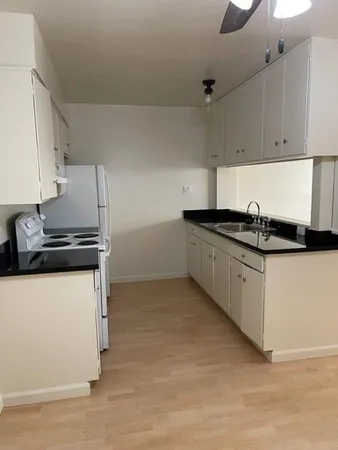 a kitchen with granite countertop a refrigerator and a stove