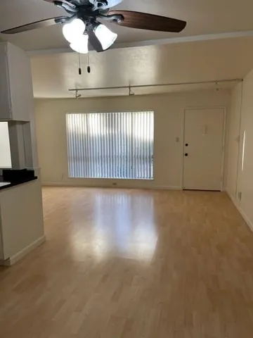 a view of an empty room with wooden floor