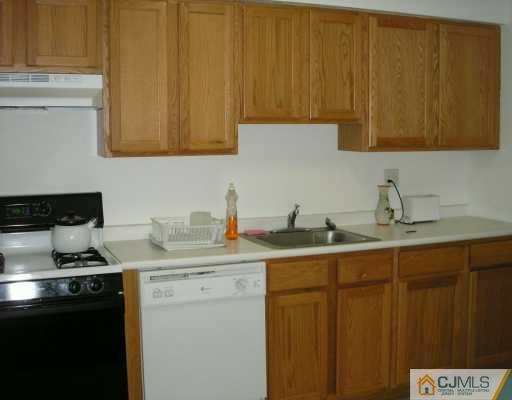 50 Fox Road, Unit 8A Edison, NJ 08817 - Photo 2 of 8 a kitchen with stainless steel appliances a sink dishwasher and cabinets with wooden floor