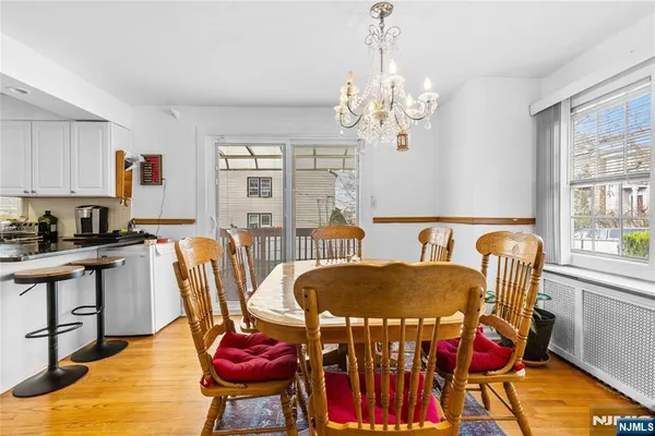 a view of a dining room with furniture a chandelier and wooden floor