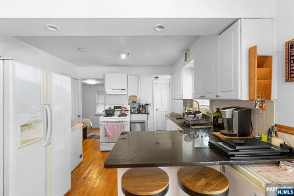 a kitchen with stainless steel appliances granite countertop a sink a stove and a refrigerator