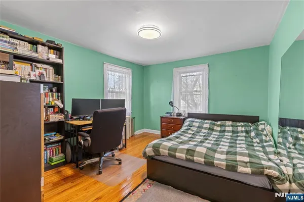 a bedroom with a bed and a computer on the desk