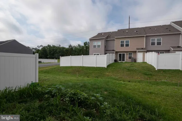 an aerial view of residential houses with outdoor space and trees