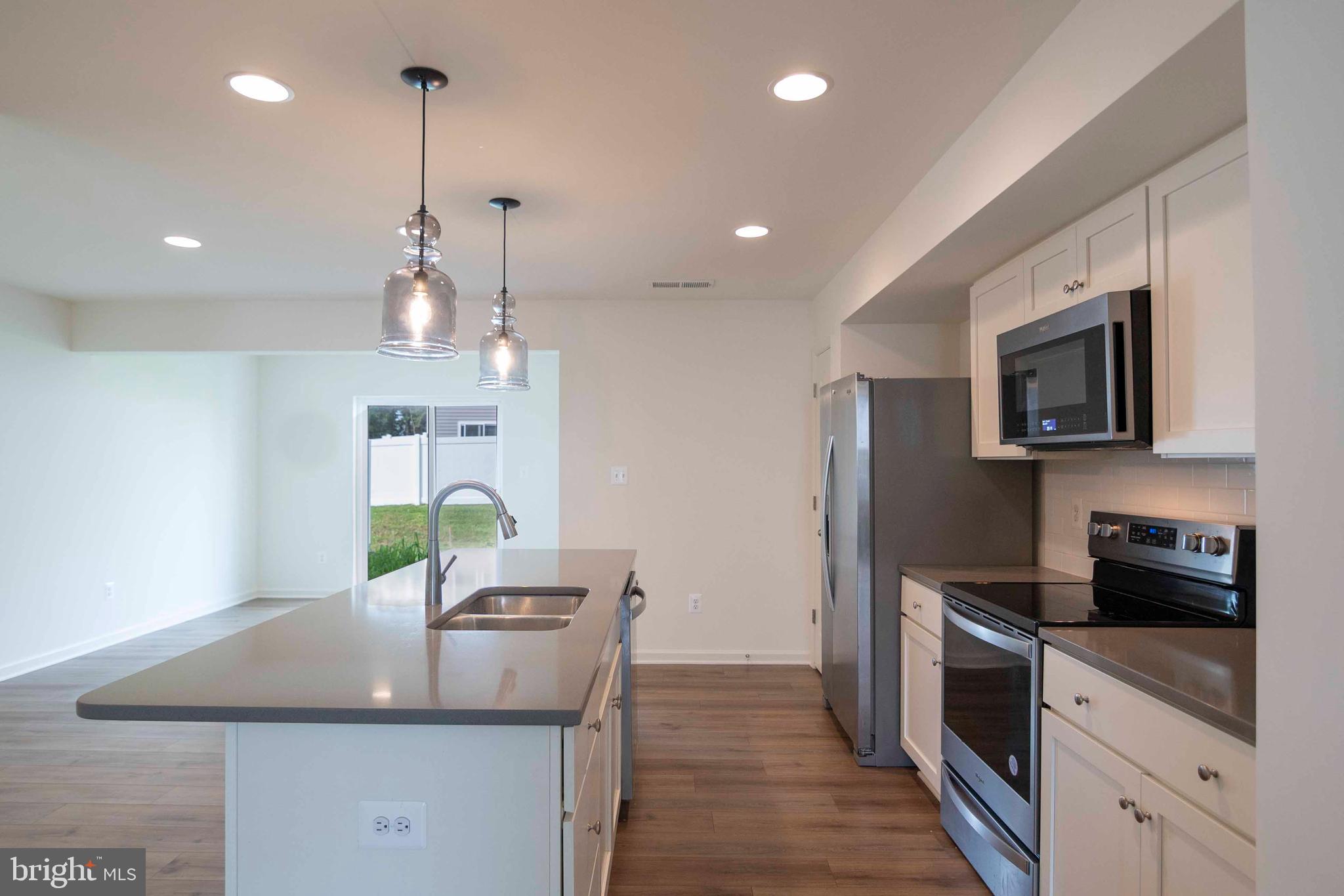 15 Pitch Pine Bunker Hill, WV 25413 - Photo 4 of 37 a kitchen with kitchen island granite countertop a sink a counter space appliances and cabinets
