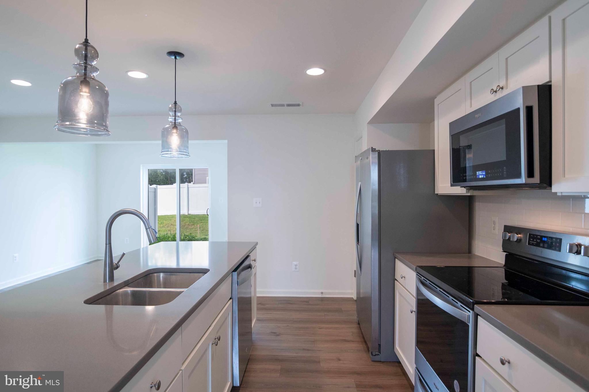 15 Pitch Pine Bunker Hill, WV 25413 - Photo 8 of 37 a kitchen with kitchen island granite countertop a sink stainless steel appliances and counter space